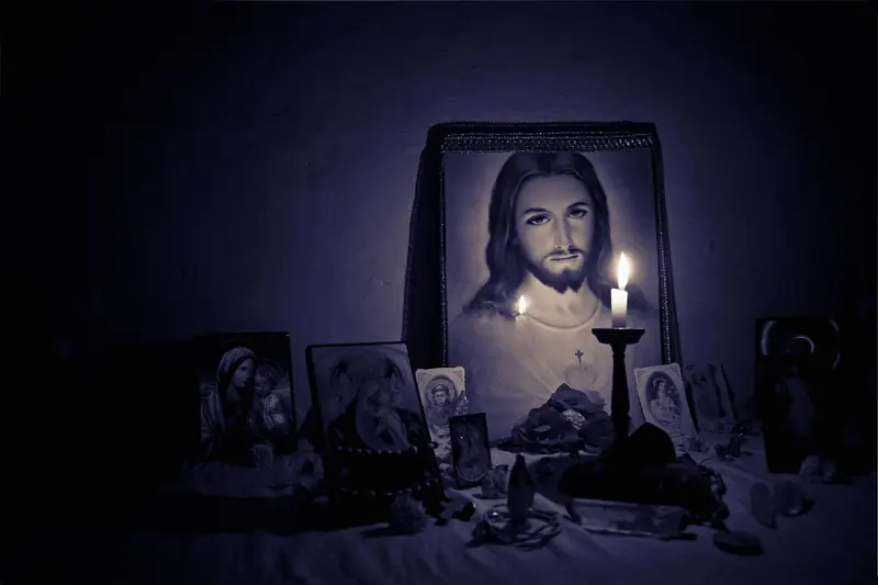 A candle in front of Sacred heart of Jesus